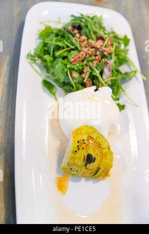 Klassische Salat mit Birne, Rucola oder rauke Blätter, gehobeltem Parmesan und Walnüsse. Beträufelt mit Olivenöl, Zitrone Essig, Burrata, gewürzt, macadamia. Stockfoto