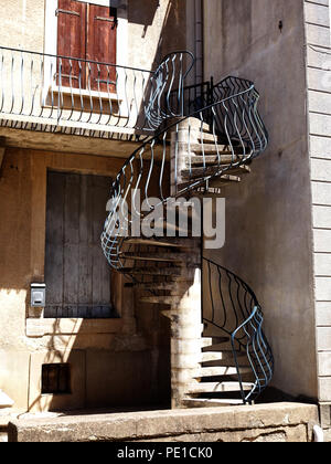 Sehr ungewöhnliche außen Wendeltreppe in Beton und Stahl, die zu einer Terrasse im ersten Stock an einer französischen Stadt Haus in Murviel-lès-Béziers, Frankreich Stockfoto