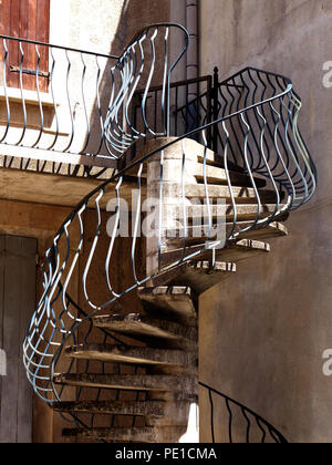 Sehr ungewöhnliche außen Wendeltreppe in Beton und Stahl, die zu einer Terrasse im ersten Stock an einer französischen Stadt Haus in Murviel-lès-Béziers, Frankreich Stockfoto