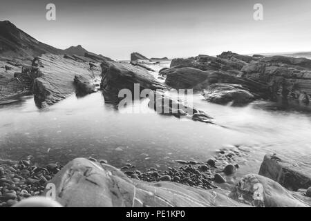 Monochrom von Felsformationen auf Widemouth Bay Strand im Sommer 2018, Bude Felsformation, Cornwall, England, Großbritannien Stockfoto