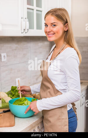 Schöne Frau, die Mahlzeit in Ihrer Küche. Stockfoto