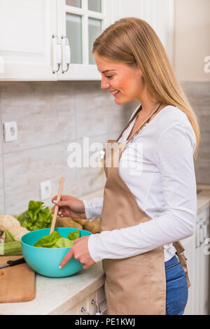 Schöne Frau, die Mahlzeit in Ihrer Küche. Stockfoto