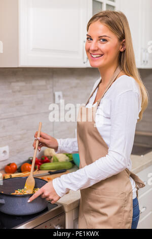 Schöne Frau kochen Mahlzeit in Ihrer Küche. Stockfoto