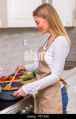 Schöne Frau kochen Mahlzeit in Ihrer Küche. Stockfoto