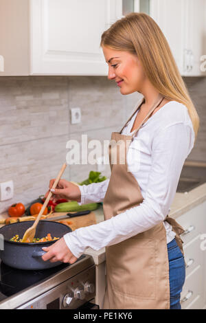 Schöne Frau kochen Mahlzeit in Ihrer Küche. Stockfoto