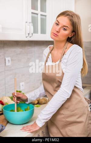 Müde Hausfrau eine Mahlzeit in Ihrer Küche. Stockfoto