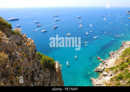 Spektakuläre Aussicht auf Capri felsige Küste mit England Yatchs und Luxus Schiffe in blau türkis Meer, die Insel Capri, Kampanien, Italien Stockfoto