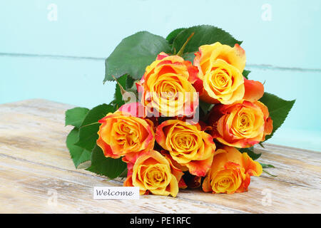 Herzlich Willkommen bei orange Rose Bouquet auf Holz- Oberfläche Stockfoto