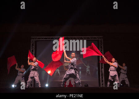 Chania, Griechenland. 10 Aug, 2018. Shaolin Teilnehmer gesehen, die mit roten Fahnen auf eine Show. Shaolin Die Legende ist eine Gruppe von Shaolin Kung Fu Meister. Fliegen Sie in der Luft, mit ihren Schwertern beeindrucken, und brechen Steine in Ihren Körper oder Kopf und ihre Körper berühren auf Spieße, alle in einer langweiligen Atmosphäre mit brennenden Kerzen und die atemberaubende Landschaft. Credit: Nikolas Joao Kokovlis/SOPA Images/ZUMA Draht/Alamy leben Nachrichten Stockfoto