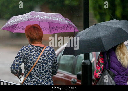 London. UK 11 Aug 2018 - Frauen im Regen mit Sonnenschirmen als Regenfälle in London. Nach dem Met Office mehr Regen vorhergesagt ist für Sonntag, den 12. August. Credit: Dinendra Haria/Alamy leben Nachrichten Stockfoto