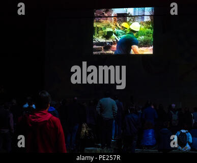 Schottland, Großbritannien. August 2018. Leith, Edinburgh Fringe Festival Outdoor-Event, Schottland, Großbritannien. Eine Wand ist eine Leinwand: Kostenlose geführte Kurzfilmwanderung mit standortspezifischen Außenvorführungen an Gebäudewänden bei einer Führung durch fünf Orte in den hinteren Straßen von Leith. Zu den Orten gehörten der soziale Wohnblock Linksview, Die Water Street und The Shore. Die Gemeinschaftspolizei eskortierte die große Menschenmenge und berichtete, dass rund 600 Personen an der Veranstaltung teilnahmen Stockfoto