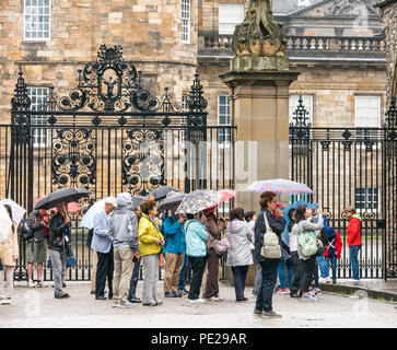 Holyrood Edinburgh, Edinburgh, Schottland, Vereinigtes Königreich, 12. August 2018. UK Wetter: Regen und Nebel, wie die Reste der Sturm Debby Hits das Kapital nicht Touristen in Holyrood Palace vor den großen verzierten Tor abhalten. Die Menschen in der Warteschlange der Palast Sonnenschirme halten eingeben Stockfoto