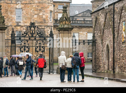 Holyrood Edinburgh, Edinburgh, Schottland, Vereinigtes Königreich, 12. August 2018. UK Wetter: Regen und Nebel, wie die Reste der Sturm Debby Hits das Kapital nicht Touristen in Holyrood Palace vor den großen verzierten Tor abhalten. Die Menschen in der Warteschlange der Palast Sonnenschirme halten eingeben Stockfoto