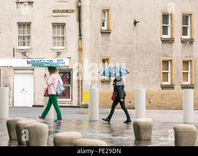 Holyrood Edinburgh, Edinburgh, Schottland, Vereinigtes Königreich, 12. August 2018. UK Wetter: Regen und Nebel, wie die Reste der Sturm Debby Hits das Kapital nicht Touristen in Holyrood Palace abhalten. Zwei Frauen halten Regenschirme Stockfoto