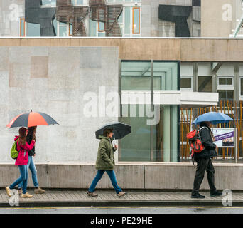 Holyrood Edinburgh, Edinburgh, Schottland, Vereinigtes Königreich, 12. August 2018. UK Wetter: Regen und Nebel, wie die Reste der Sturm Debby Hits das Kapital nicht Touristen am Schottischen Parlamentsgebäude abzuhalten. Menschen zu Fuß halten Regenschirme Stockfoto