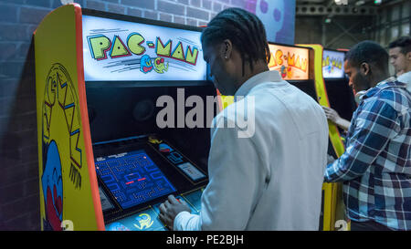 London, Großbritannien. 12. August 2018. Besucher spielen Pac-Man an Retro Games Festival spielen Expo in London zum ersten Mal auf der Printworks, Kanada Wasser gehalten. Spiel Enthusiasten besucht die Klassiker zu entdecken, von Donkey Kong, Pong, Super Mario Bros. und Space Invaders, die Vintage pinball Maschinen, VR, Indie Games und einem engagierten Minecraft Zone. Die Show gehörte auch eine Vorschau der neuen Retro Gaming streaming Service, Antstream. Credit: Stephen Chung/Alamy leben Nachrichten Stockfoto