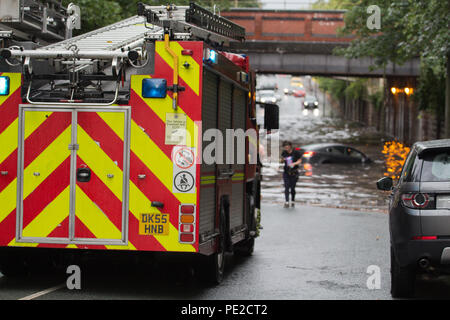 Liverpool, Großbritannien. 12 August, 2018. UK Wetter. Junge Paare sind in Ihrem Auto eingeschlossen, nachdem Überschwemmungen Liverpool schlagen. Die Paare wurden auf Queens Drive L 18 auf einem berüchtigten Sprung in der Straße gefangen, nach dem Kampf gegen das steigende Wasser sie schließlich durch das Wasser wateten gerade als die Feuerwehr eintraf. Credit: Ken Biggs/Alamy Leben Nachrichten. Stockfoto