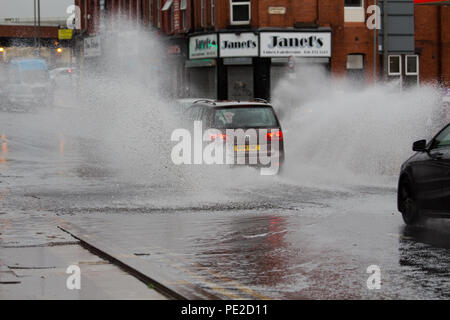 Liverpool, Großbritannien. 12 August, 2018. UK Wetter. Autos fahren durch Überschwemmungen auf Smithdown Road, Liverpool, 15 nach dem sintflutartigen Regen die Straße überflutet. Credit: Ken Biggs/Alamy Leben Nachrichten. Stockfoto