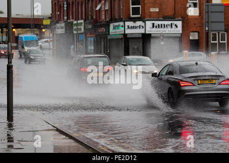 Liverpool, Großbritannien. 12 August, 2018. UK Wetter. Autos fahren durch Überschwemmungen auf Smithdown Road, Liverpool, 15 nach dem sintflutartigen Regen die Straße überflutet. Credit: Ken Biggs/Alamy Leben Nachrichten. Stockfoto