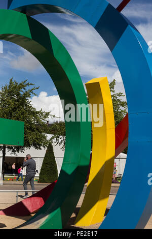 Mann hinter dem Logo der Glasgow Commonwealth-Spiele 2014 in Glasgow, Schottland, am 10. August 2018. Stockfoto