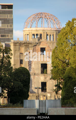 Die Atombombe Kuppel (Genbaku Dōmu), Teil des Hiroshima Peace Memorial in einer Linie durch das Ehrenmal und über den Frieden Flamme in Hiroshima gesehen. Stockfoto