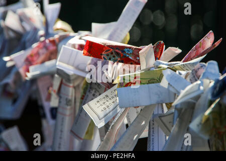 Omikuji (wahrsagerei Streifen Papier) mit einem Seil an einem japanischen Tempel in Nikko, Japan gebunden. Stockfoto