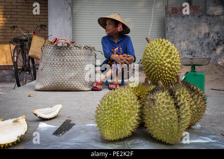 Eine vietnamesische Frau sitzt auf der Straße verkaufen durians, Ho Chi Minh City, Vietnam Stockfoto