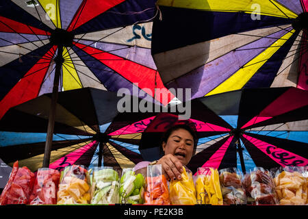 Eine Frucht der Anbieter unter bunten Sonnenschirmen, um Ihre Waren in Bangkok, Thailand Hawking. Stockfoto