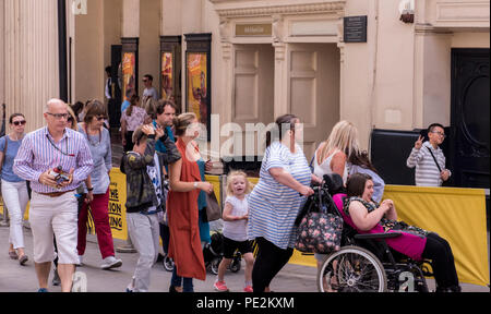 Hektik der Menschen vorbei gehen. Theater, junge Junge hinter Theater Barriere geben Frieden unterzeichnen. London, England, Großbritannien Stockfoto