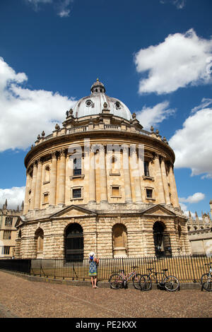 Frau, die an der die Radcliffe Camera Teil der Bodleian Library in Oxford England UK Radcliffe Square gelegen auf der Suche Stockfoto