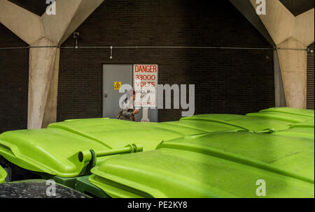 Große kommerzielle Abfallbehälter in Street, Person im Hintergrund, London, England, Großbritannien Stockfoto