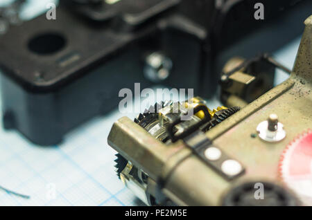Teile sind vollständig demontiert alten retro Film SLR Kamera auf Millimeterpapier, close-up Stockfoto