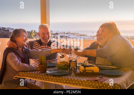 Nette Gruppe der kaukasischen erwachsener Menschen in Glück bleiben zusammen für Abendessen im Freien auf der Terrasse. liebe und freundschaft Konzept mit herrlichen Ausblick. v Stockfoto