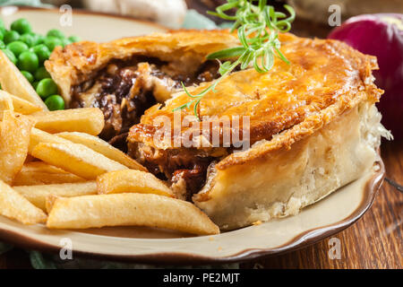 Rindergulasch mit hausgemachten Kuchen mit Pommes frites. Fleisch in Blätterteig Stockfoto