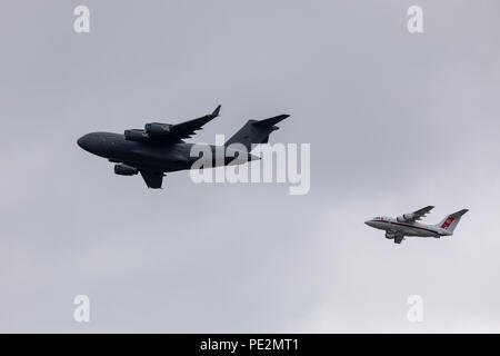 Ein RAF C-17 Globemaster III Flugzeuge in Formation auf niedrigem Niveau mit einer BAE 146 Overhead für die RAF 100. Jahrestag fliegen Stockfoto