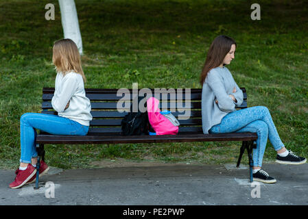 Zwei Mädchen Schülerin stritten sich im Sommer im Park. Sie sitzen auf einer Bank. Das Konzept der Konflikt, Skandal, Probleme in der Familie, Unzufriedenheit. E Stockfoto