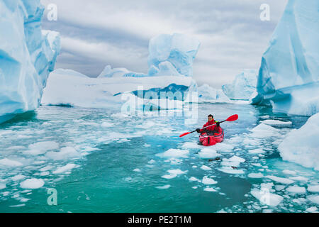 Extreme Tourismus, winter Kajak in der Antarktis, abenteuerliche Mann paddeln auf Sea Kayak zwischen Eisbergen Stockfoto