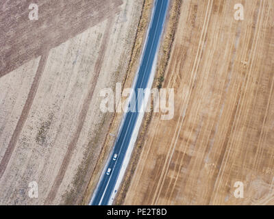 Luftaufnahme der Asphaltstraße von Drohne, von oben nach unten von zwei Autos fahren, Geometrie Landschaft Stockfoto