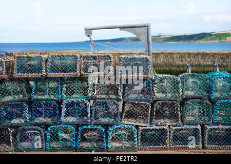 Stapel von Hummer net Töpfe am Hafen mit Steinmauer für Angler Meer Fisch und Nahrung zu fangen Stockfoto