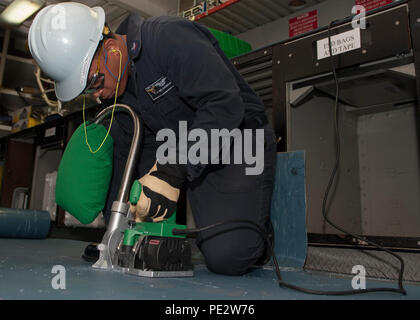 150922-N-ZZ 999-056 SAN DIEGO (Sept. 22, 2015) der Luftverkehr Elektriker Mate 2. Klasse Antonio Harrison schneidet elektrische Matten an Bord der Flugzeugträger USS Carl Vinson (CVN 70). Carl Vinson unterzieht sich einem Chef der Marineoperationen geplante schrittweise Verfügbarkeit Mindestreserve-erfüllungsperiode in ihren Heimathafen San Diego. (U.S. Marine Foto von Mass Communication Specialist Seaman Tom Tonthat/Freigegeben) Stockfoto