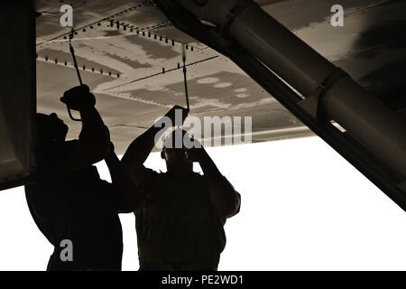 Tech. Sgt Nasir Ahmad und Flieger 1. Klasse James Balcom, 37th Aircraft Maintenance Unit Crew Chiefs, ein Panel unter einer B1-B Lancer entfernen auf Dichtheit als Teil einer endgültigen Pre-flight inspection Sept. 22, 2015 Al Udeid Air Base, Katar. Ahmad und Balcom sind von Ellsworth Air Force Base, S.D. (USA bereitgestellt Air Force Foto/Staff Sgt. Alexandre Montes) Stockfoto