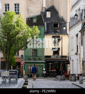 Straßenszene entlang der Rue Saint-Julien Le Pauvre mit einem Café ein eigenartiges Gebäude im Hintergrund in Paris, Frankreich. Stockfoto