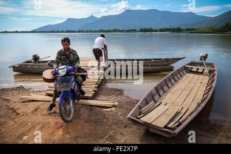 Eine Gruppe von Studenten mit einem Holz- Fähre der Mekong River Crossing im Muang in der Nähe von Champasak, Pakse, in Laos. Stockfoto