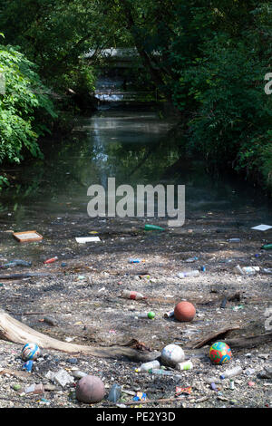 Flussverschmutzung, die in der Nähe eines Verschmutzungsrostes, River Brent, in der Nähe des Brent Reservoirs, auch bekannt als Welsh Harp Reservoir, Brent, London, Vereinigtes Königreich, gesammelt wurde Stockfoto