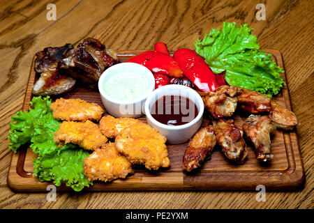 Schweinerippchen mit Honig Sauce, würzige Chicken Wings, gegrillte Paprika, Chicken Nuggets, Barbecue Sauce, Knoblauch Sauce. Stockfoto