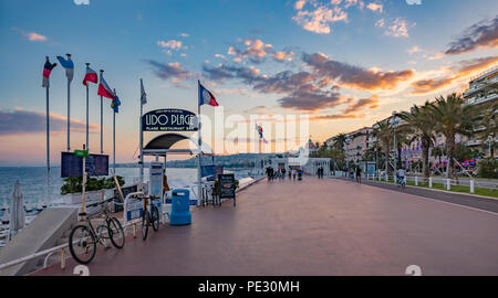 Nizza, Frankreich - 23. Mai 2018: Blick auf den Strand und das Mittelmeer Küste mit berühmten Hotel Negresco im Hintergrund bei Sonnenuntergang, Cote d'Azur, Stockfoto