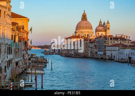 Sonnenuntergang an der Ikone aus dem 17. Jahrhundert Santa Maria di Salute Basilika, Ansicht von Academia Brücke oder Puente de La Academia entlang des Canal Grande in Venedig, Stockfoto