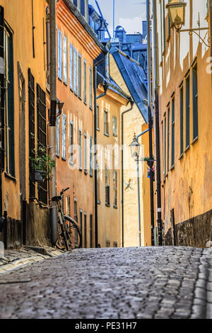 Schweden malerische Straße mit Kopfsteinpflaster im malerischen Gamla Stan, Stockholms älteste Nachbarschaft. Geparkt Fahrrad gegen ein Gebäude lehnend. Radfahren ist ein po Stockfoto