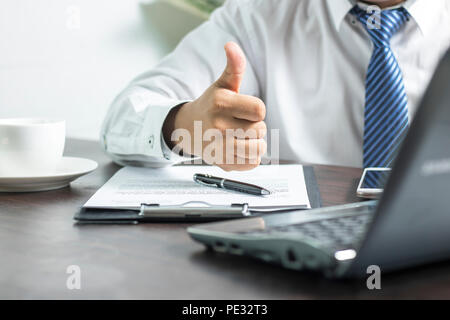 Geschäftsmann mit Daumen zu bestätigen und auf "ok" über erfolgreiche Vertrag nach Ende der Unterzeichnung auf Papier Stockfoto