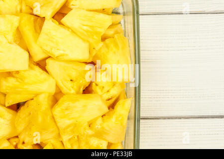 Tischplatte - Nahaufnahme der reife Ananas in Stücke schneiden, in Glasschale auf White boards Schreibtisch platziert. Stockfoto